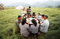 
	خانواده چینی که در خارج از خانه برای خوردن غذا دور یکدیگر جمع شده&zwnj;اند. خانه آنها در زلزله 6 ریشتری شهر سیچوان ویران شده است.
